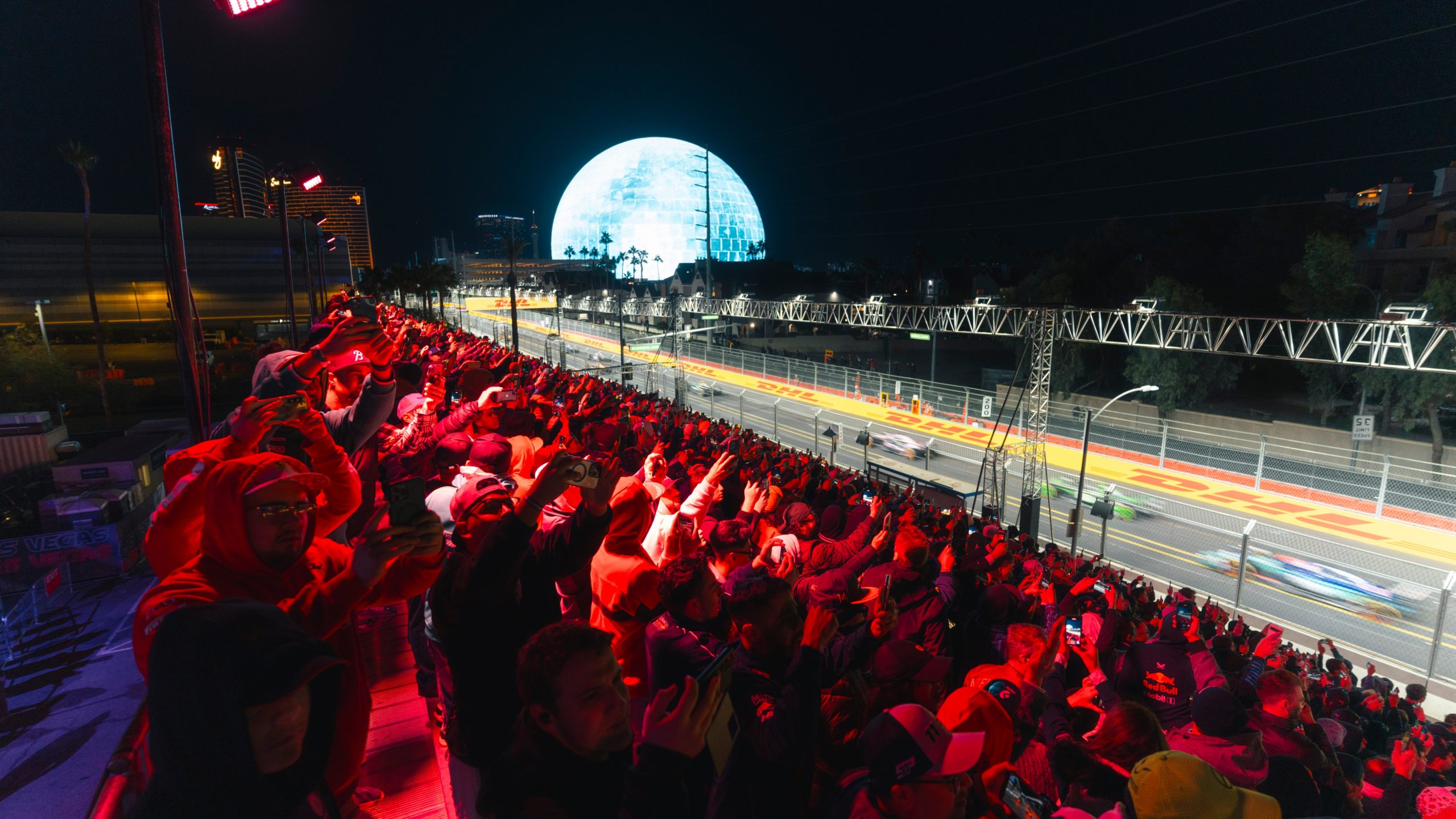 Cars speeding past full grandstand